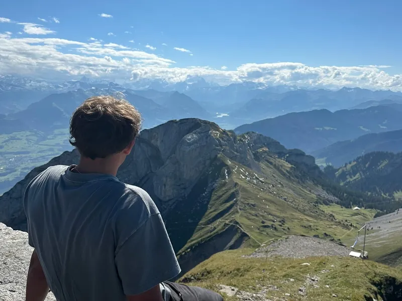 Roanin sitting on a rock looking out over the Alps