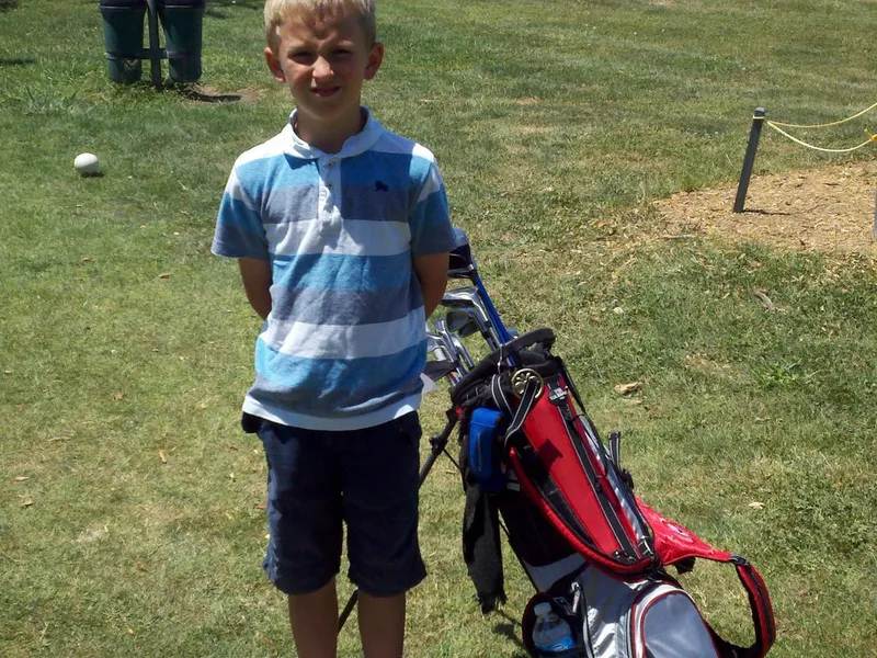 Roanin as a kid with a golf bag on a course
