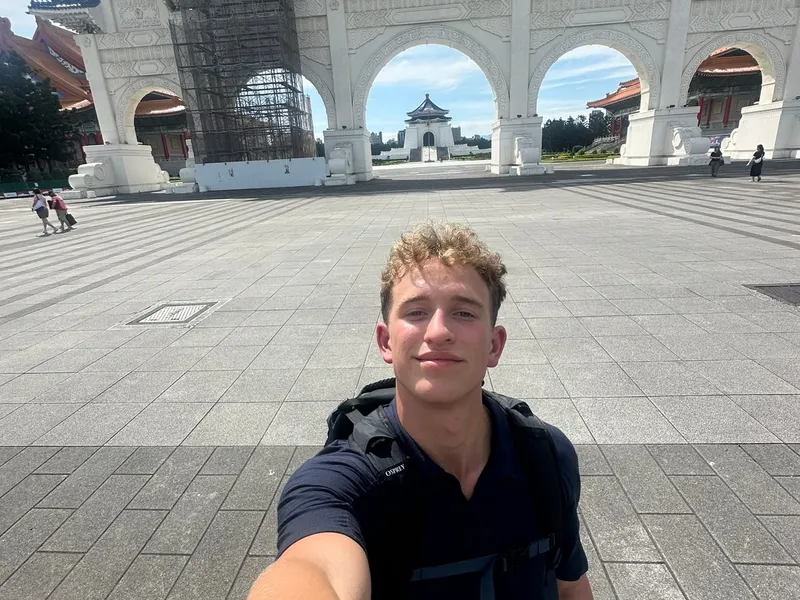 Roanin with a backpack in front of the Liberty Square gate in Taipei