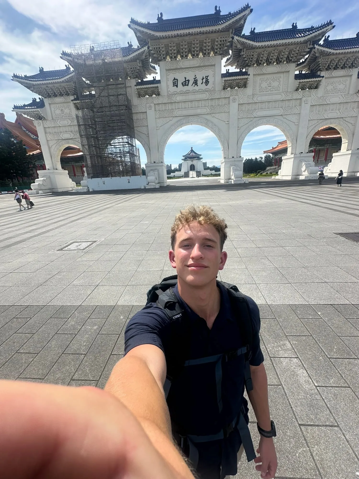 Me with a backpack in front of the Liberty Square gate in Taipei