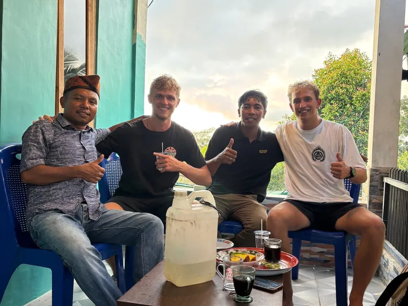 Roanin and three new friends on a porch in Flores, all giving thumbs up