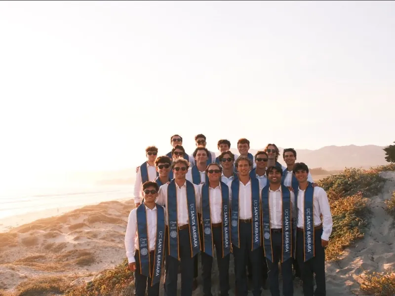 Roanin and about twenty friends in UC Santa Barbara Class of 2026 sashes on the dunes at sunset