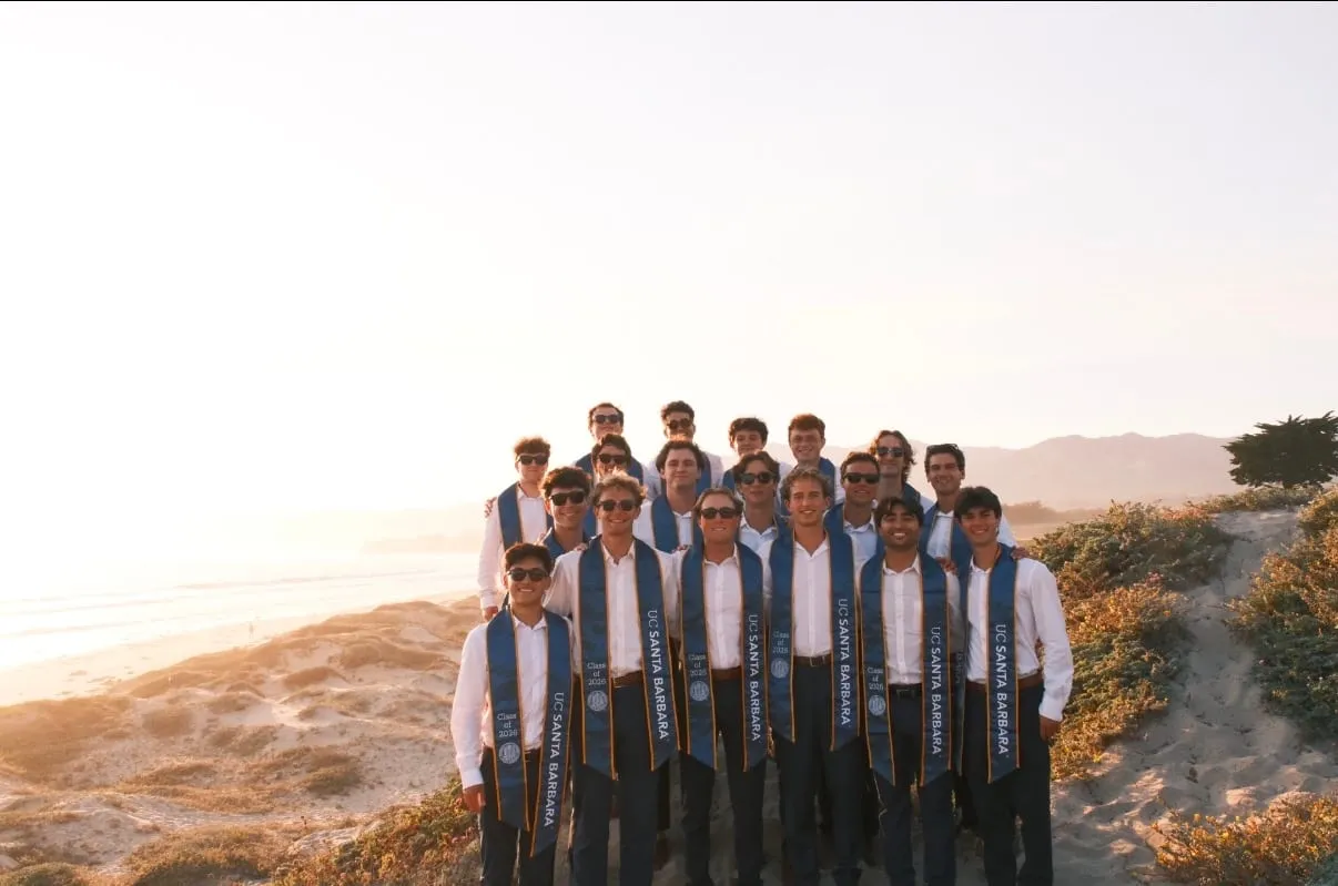 Roanin and about twenty friends in UC Santa Barbara Class of 2026 sashes on the dunes at sunset